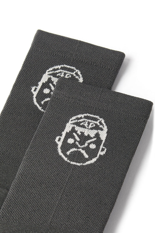 A detailed photo of the face logo on the Angry Pablo grey cycling socks