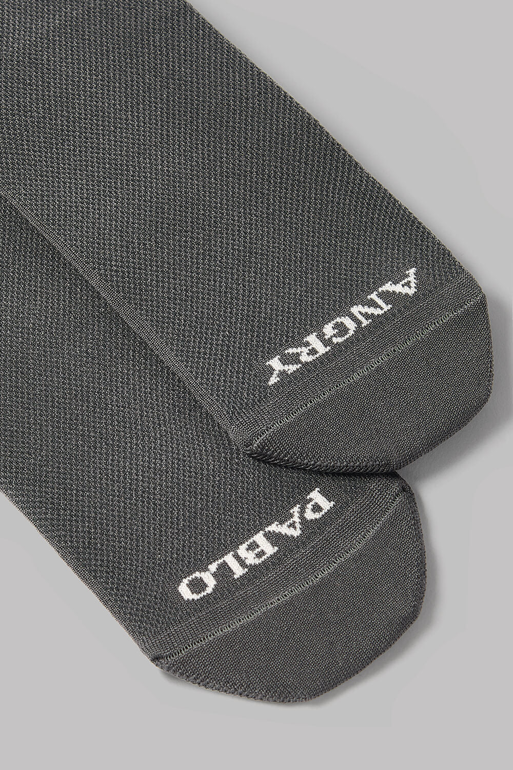 Gray socks with text on the ankle area against a light gray background