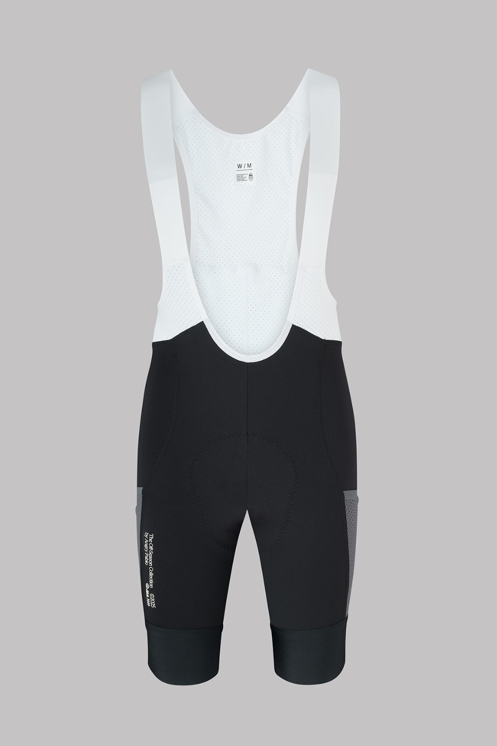 Black cycling bib shorts with white top on a gray background