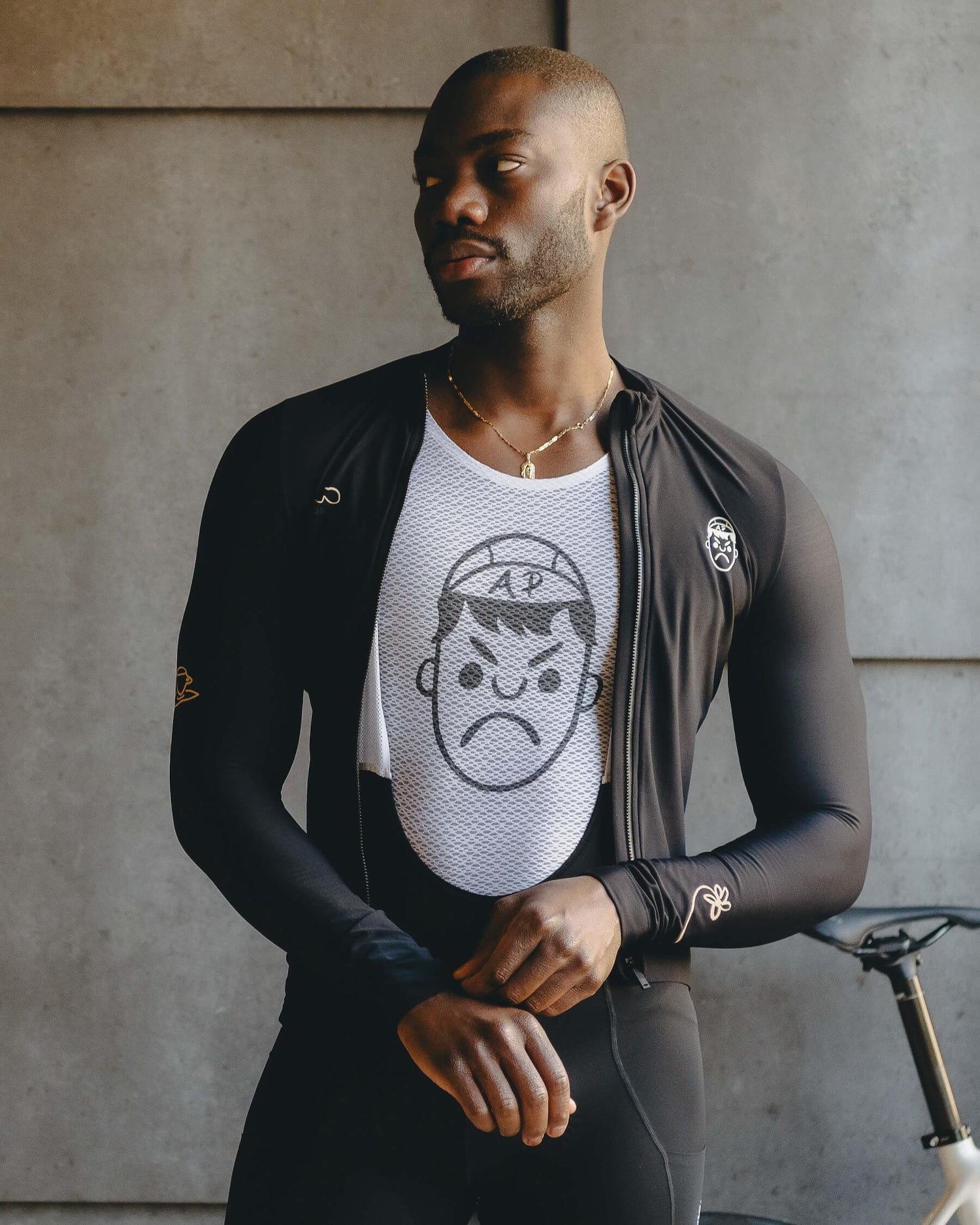 A cyclist wearing a white cycling mesh base layer in front of their bike